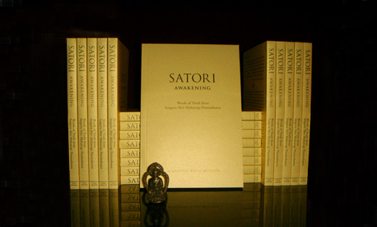 stack of Satori books with a small Buddha statue in front